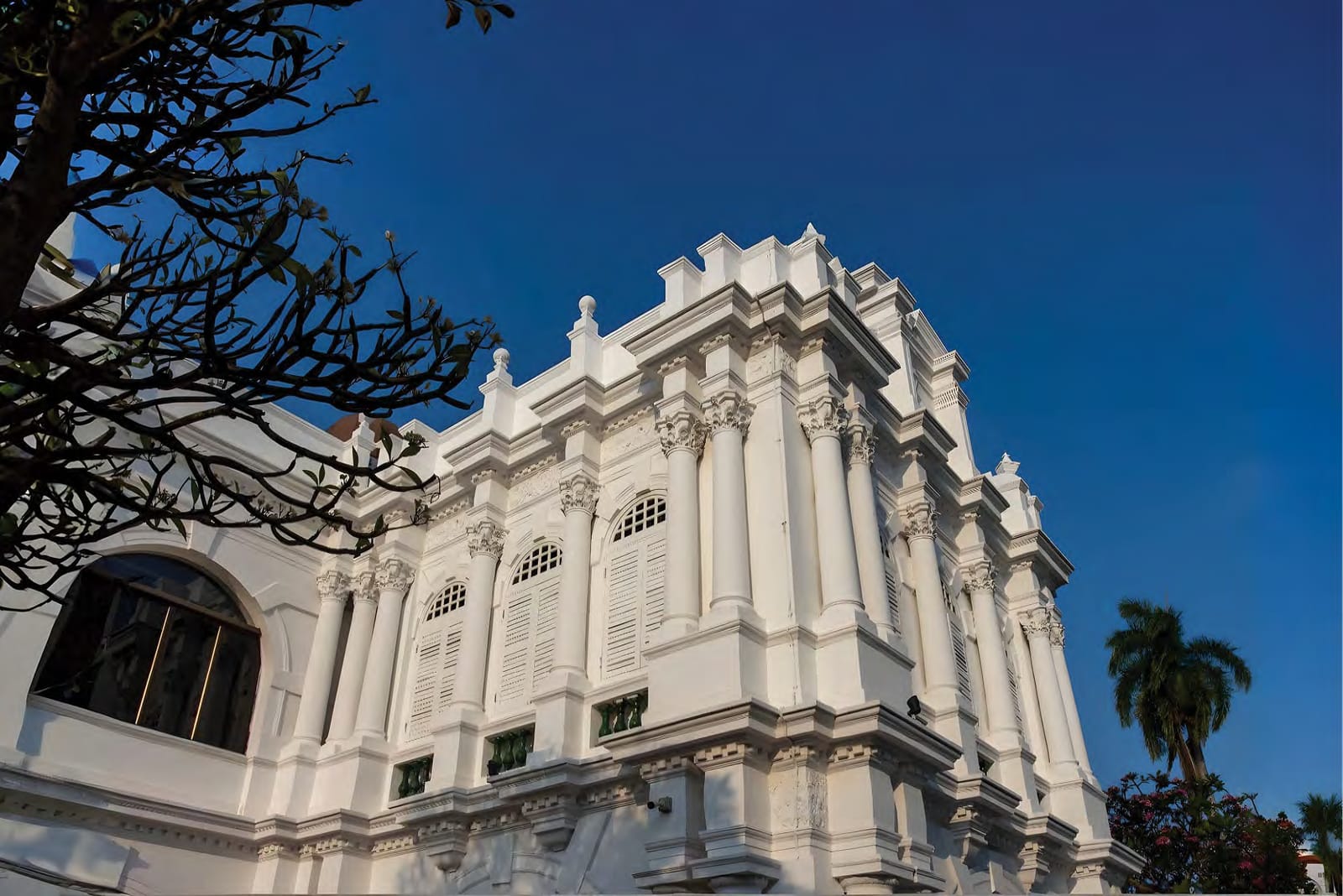 White colonial heritage building in George Town under a deep blue sky